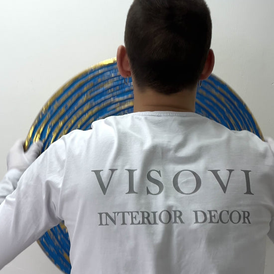 Textured 3D spiral wall panel in prime blue with gold leaf shown in motion and lighting