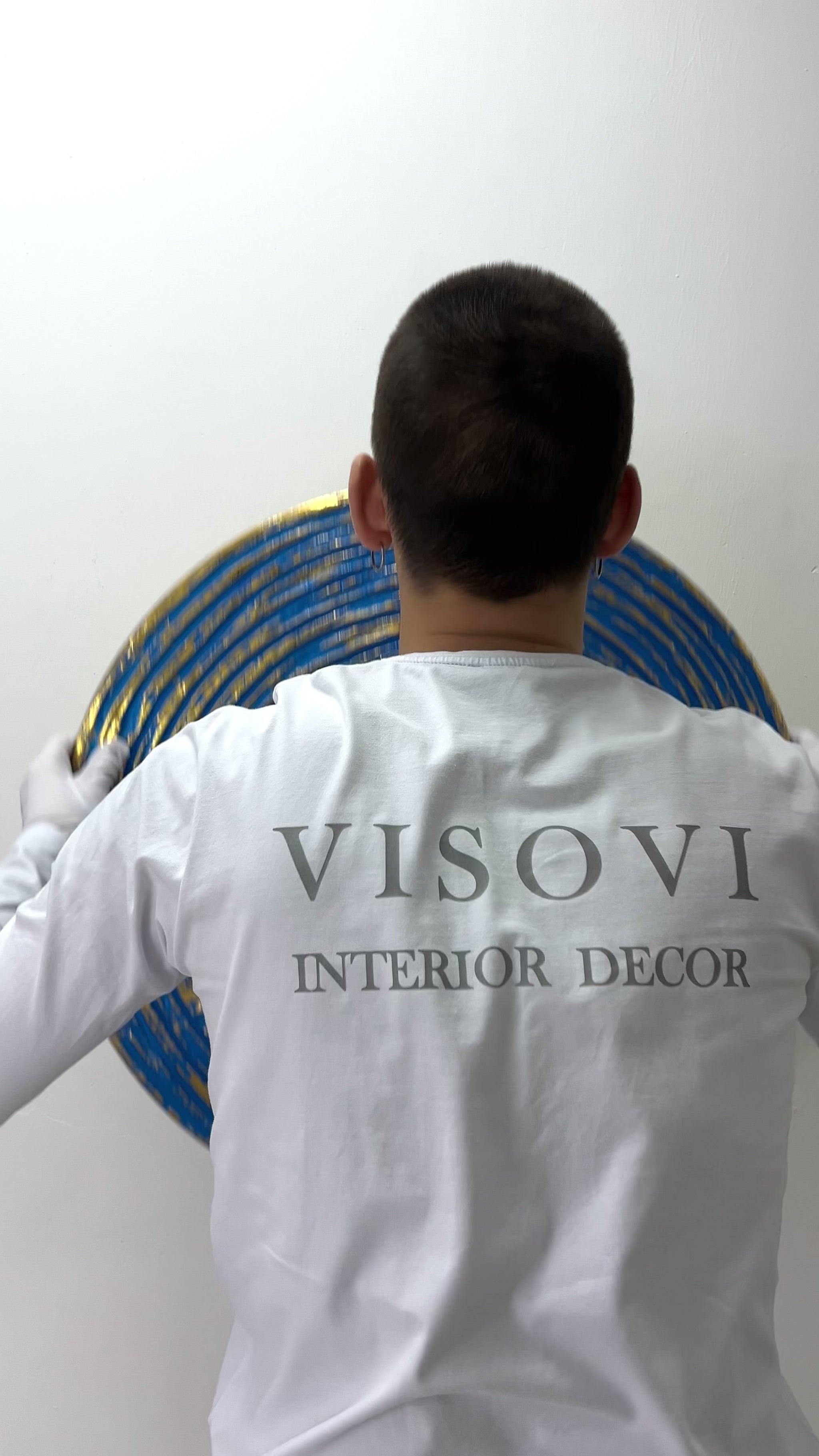 Textured 3D spiral wall panel in prime blue with gold leaf shown in motion and lighting